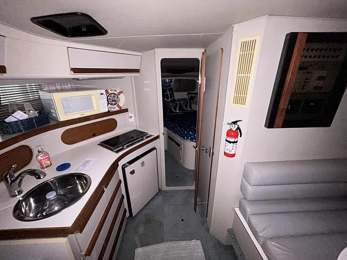 Slide: The Image of Interior of a 1990 Carver 3257 Montego boat with kitchenette and seating area. - 27