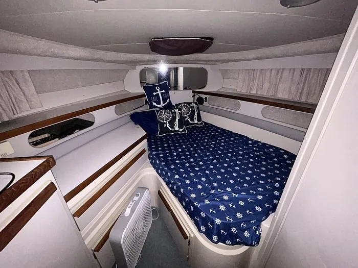 Slide: The Image of 1990 Carver 3257 MONTEGO cabin with nautical-themed bedding and cozy interior. - 28