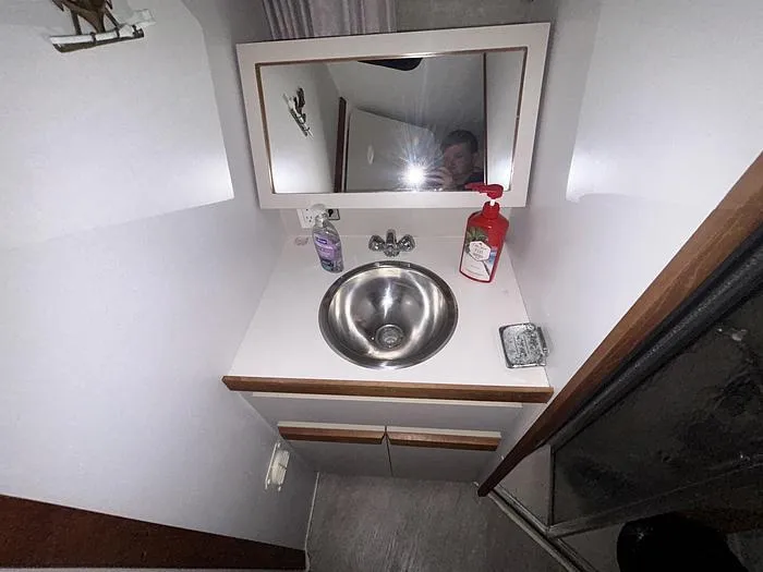 Slide: The Image of Compact bathroom vanity in a 1990 Carver 3257 MONTEGO boat, featuring a sink and mirror. - 30