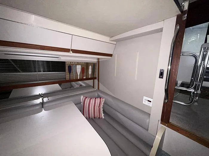 Slide: The Image of Interior of 1990 Carver 3257 MONTEGO boat with seating area and striped pillow. - 35