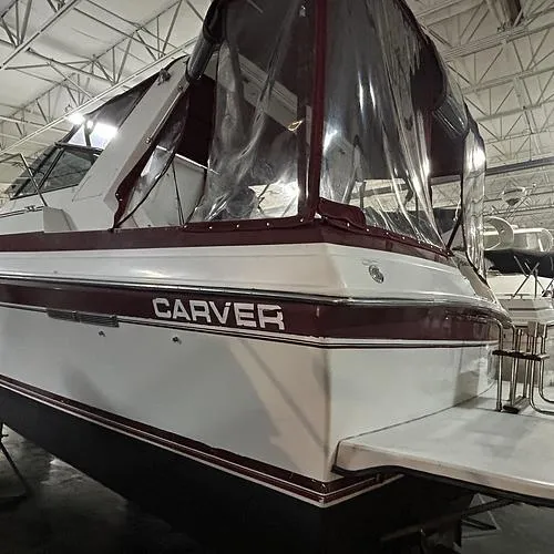Slide: The Image of 1990 Carver 3257 Montego boat with maroon trim in a storage facility. - 4