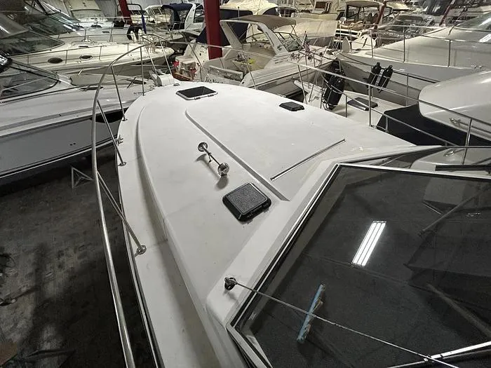 Slide: The Image of 1990 Carver 3257 Montego boat in a marina, surrounded by other vessels. - 8