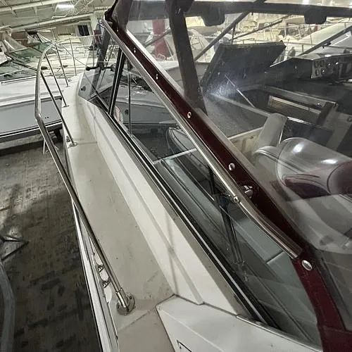 Slide: The Image of 1990 Carver 3257 MONTEGO boat with maroon trim, docked indoors. - 9