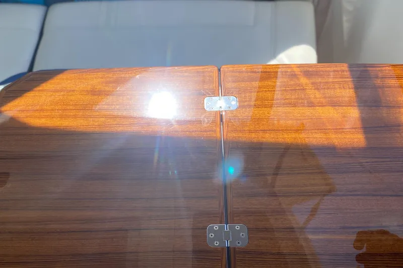 Slide: The Image of Polished wooden surface with metal hinges on a 2021 Tiara Yachts 38LX. - 11