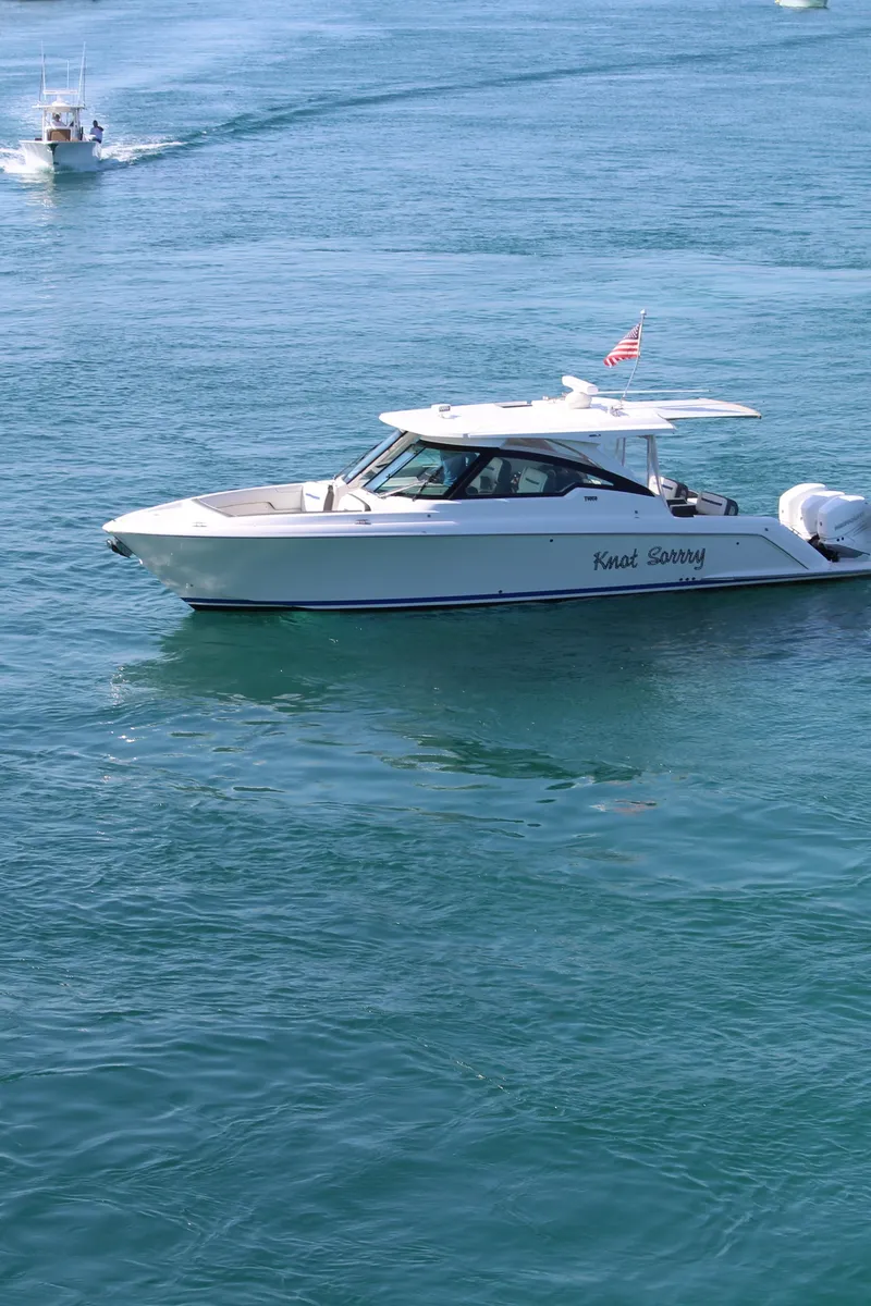 Slide: The Image of 2021 Tiara Yachts 38LX boat named "Knot Sorry" cruising on clear blue water. - 2