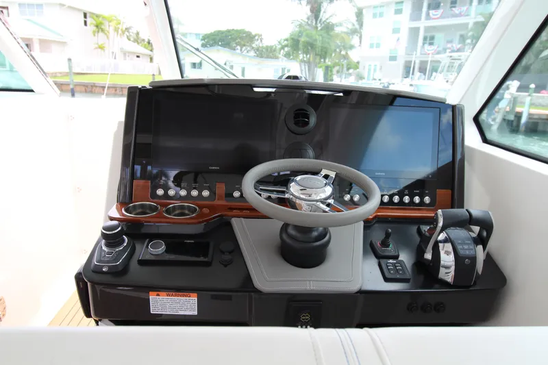 Slide: The Image of 2021 Tiara Yachts 38LX helm with modern controls and dual screens. - 7