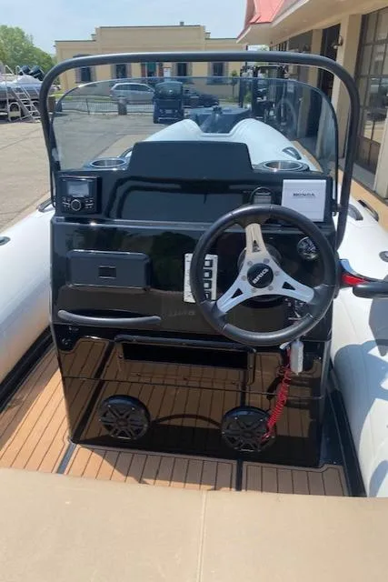 Slide: The Image of 2021 Brig Navigator 485 boat dashboard with steering wheel and controls. - 2