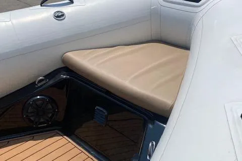 Slide: The Image of 2021 Brig Navigator 485 boat interior with beige seating and wood flooring. - 4