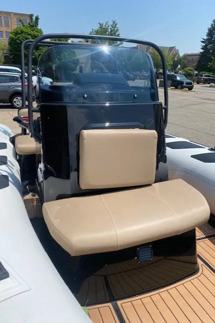Slide: The Image of 2021 Brig Navigator 485 boat with beige seating and black console in a parking lot. - 5