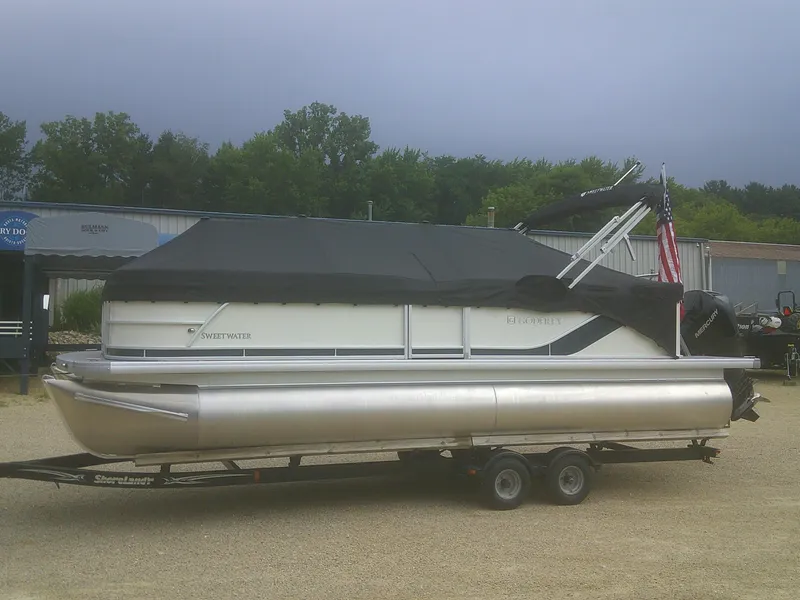 Slide: The Image of 2026 Godfrey 2286 Sweetwater Cruise Special Edition pontoon boat on trailer, covered and parked. - 19