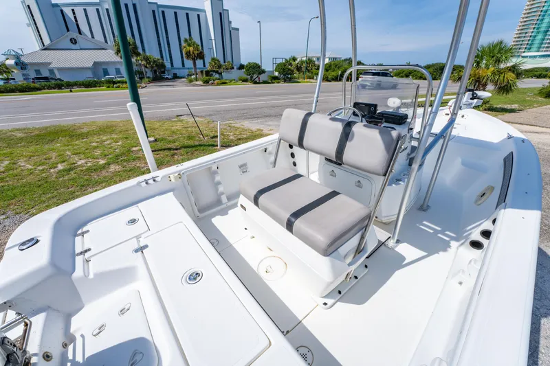 Slide: The Image of 2008 Sea Chaser 170 Bay Runner boat interior with seating and console, parked near a road. - 12