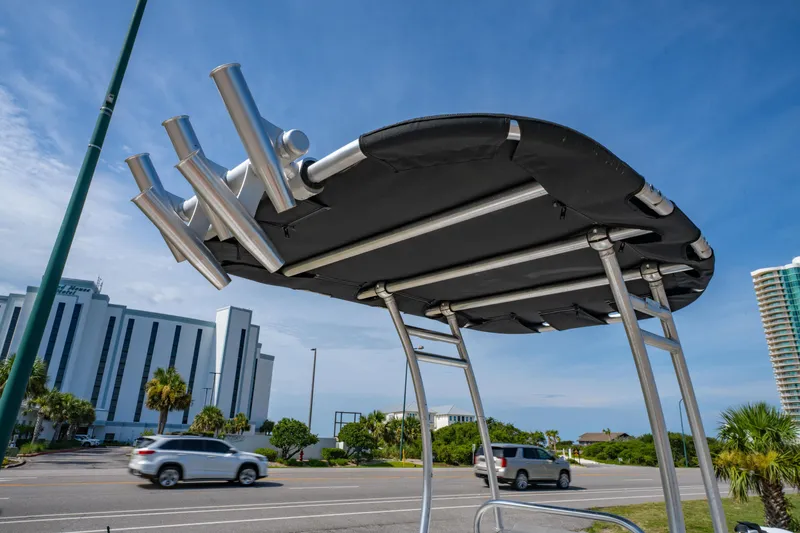 Slide: The Image of T-top of a 2008 Sea Chaser 170 Bay Runner boat with rod holders, against urban backdrop. - 13