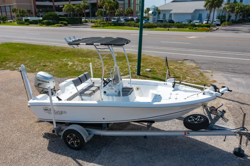 Slide: The Image of 2008 Sea Chaser 170 Bay Runner boat on trailer, parked near road, featuring Honda outboard motor. - 23