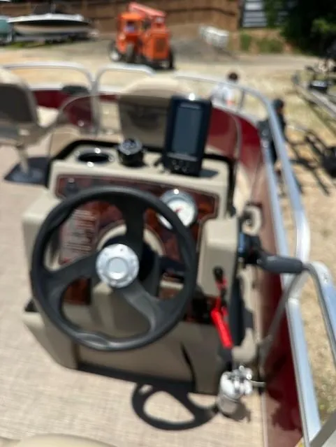 Slide: The Image of 2024 Sun Tracker Bass Buggy 16 XL Select boat dashboard with steering wheel and controls. - 10