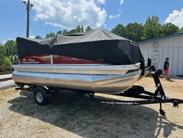 Slide: The Image of 2024 Sun Tracker Bass Buggy 16 XL Select pontoon boat covered on a trailer. - 16