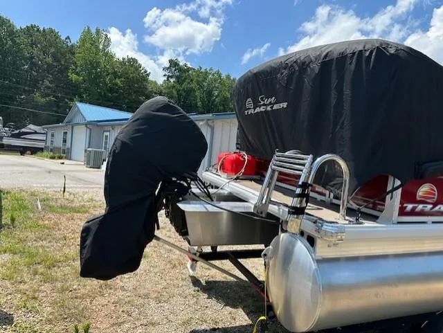 Slide: The Image of 2024 Sun Tracker Bass Buggy 16 XL Select pontoon boat, covered and parked outdoors. - 19