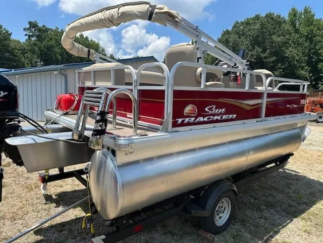 Slide: The Image of 2024 Sun Tracker Bass Buggy 16 XL Select pontoon boat on trailer, outdoors. - 6