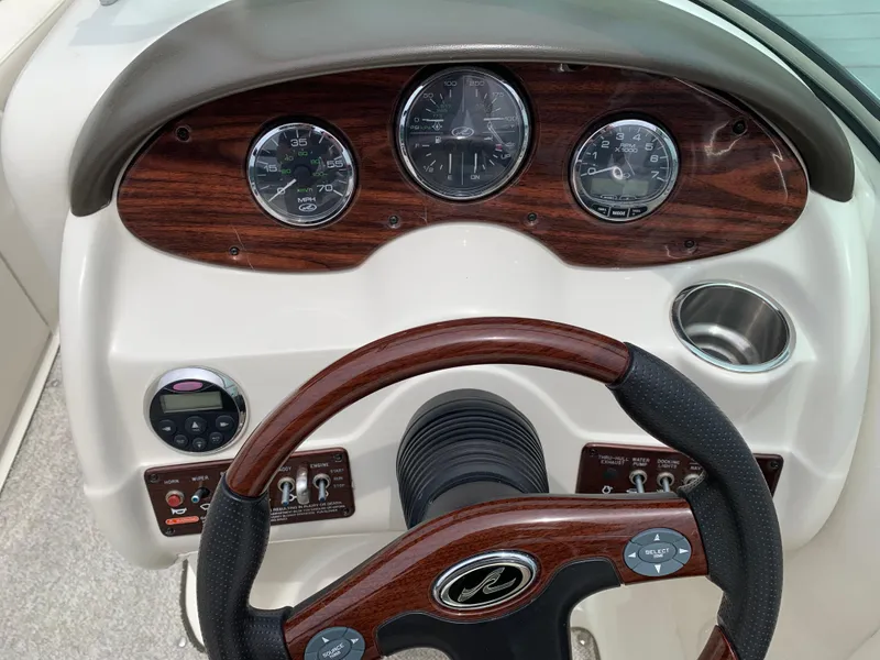 Slide: The Image of Dashboard of 2008 Sea Ray 200 Sundeck with wood accents and steering wheel. - 7