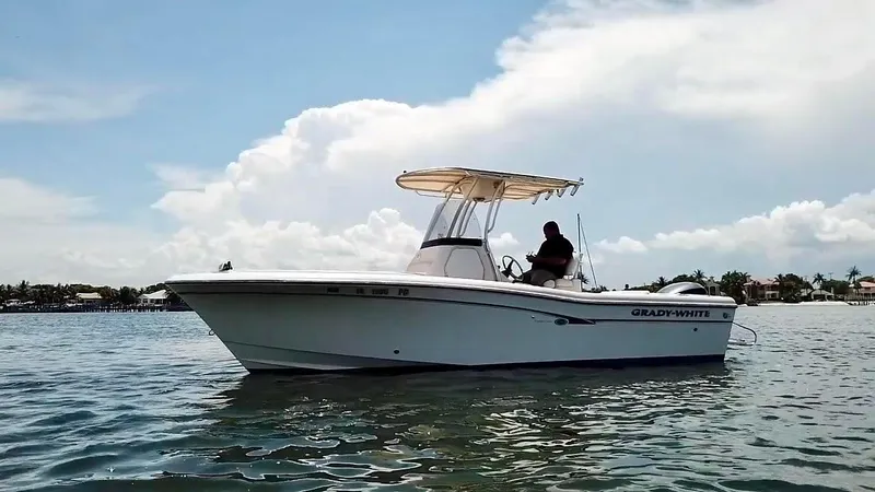 Slide: The Image of 2012 Grady-White Fisherman 230 boat on calm water under a cloudy sky. - 0