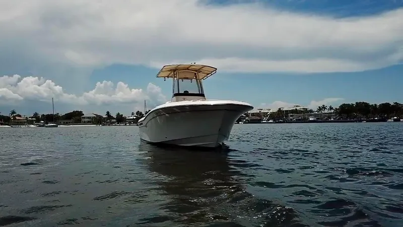 Slide: The Image of 2012 Grady-White Fisherman 230 boat on calm water under a partly cloudy sky. - 1