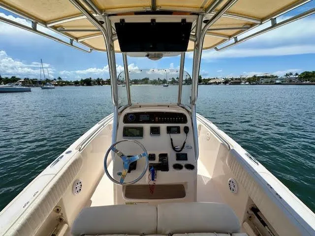 Slide: The Image of 2012 Grady-White Fisherman 230 boat interior with steering wheel and controls on a sunny day. - 10