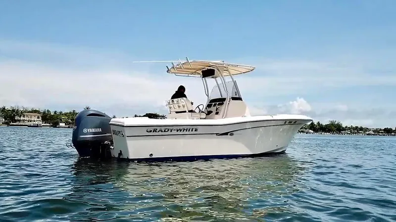 Slide: The Image of 2012 Grady-White Fisherman 230 boat on water with Yamaha engine, clear sky background. - 3