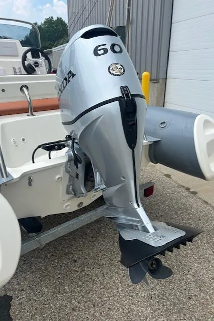 Slide: The Image of 2022 Brig Navigator 485 with Honda 60 outboard motor, parked on a trailer. - 3