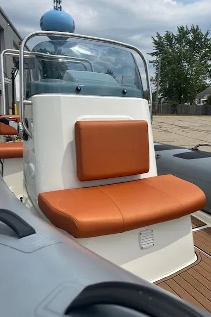 Slide: The Image of 2022 Brig Navigator 485 boat with orange seating, docked outdoors. - 4