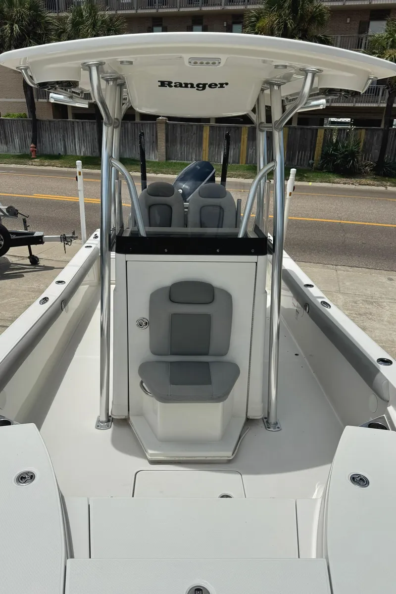 Slide: The Image of 2016 Ranger 2510 Bay Ranger boat with T-top and seating, parked on a street. - 9