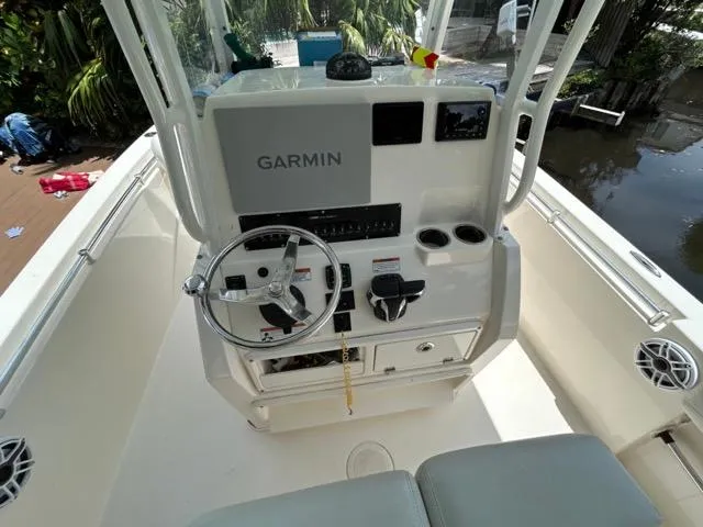 Slide: The Image of Twin Yamaha outboard engines on a 2022 Cobia 240 Center Console boat docked by foliage. - 15