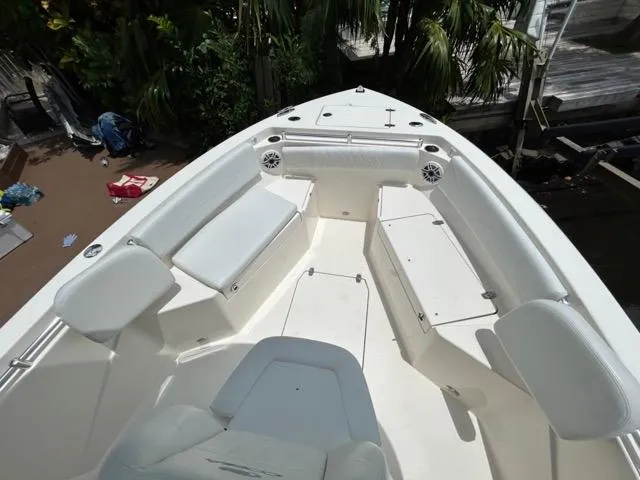 Slide: The Image of 2022 Cobia 240 Center Console boat docked, featuring Yamaha engine, surrounded by tropical scenery. - 25