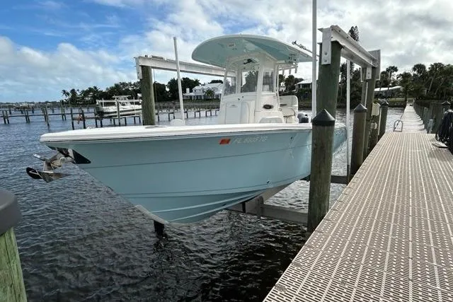 Slide: The Image of 2022 Cobia 240 Center Console boat with dual Yamaha 150 engines docked by the water. - 27