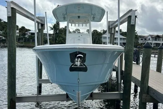 Slide: The Image of 2022 Cobia 240 Center Console boat docked on a lift by waterfront homes. - 32
