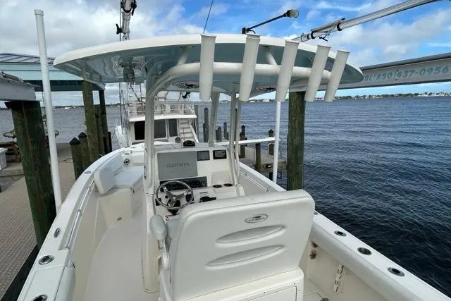 Slide: The Image of 2022 Cobia 240 Center Console boat docked by the water, featuring a sleek design. - 38