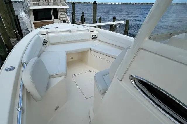 Slide: The Image of 2022 Cobia 240 Center Console boat interior with seating, docked by the water. - 42