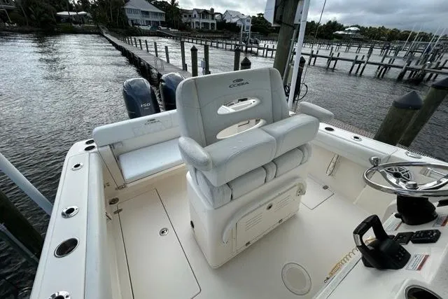 Slide: The Image of 2022 Cobia 240 Center Console boat with dual engines docked by waterfront homes. - 45