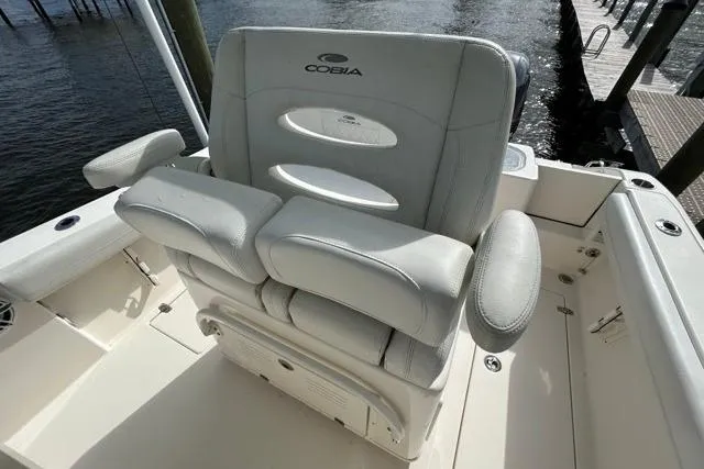 Slide: The Image of 2022 Cobia 240 Center Console boat seat, white leather, dockside view. - 50