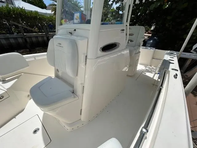 Slide: The Image of 2022 Cobia 240 Center Console boat docked by lush greenery and waterfront homes. - 7