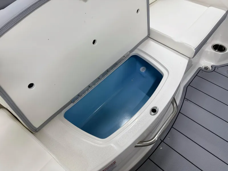 Slide: The Image of 2025 Chaparral 21 SSi boat storage compartment with open lid and blue interior. - 19