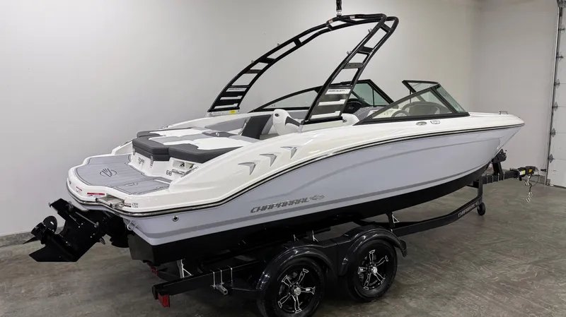 Slide: The Image of 2025 Chaparral 21 SSi boat on trailer in showroom, featuring sleek design and modern features. - 2