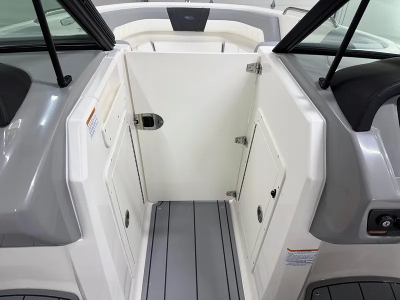 Slide: The Image of 2025 Chaparral 21 SSi boat interior with white and gray seating and storage compartments. - 21