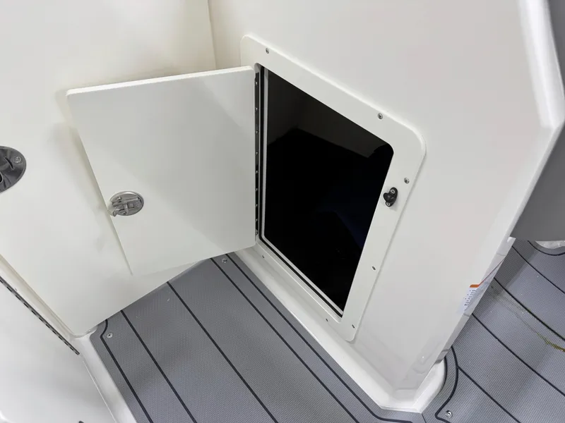 Slide: The Image of Open storage compartment on 2025 Chaparral 21 SSi boat with gray flooring. - 22