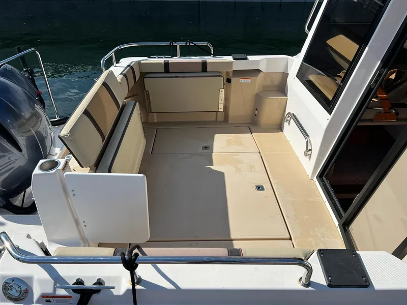 Slide: The Image of 2018 Ranger Tugs R23 boat deck with seating, open door, and water view. - 10