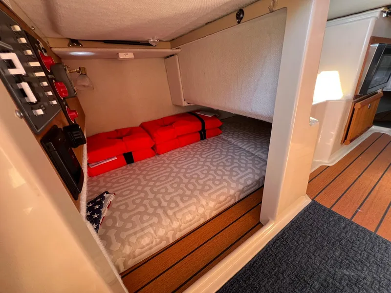 Slide: The Image of 2018 Ranger Tugs R23 cabin interior with bed, life jackets, and control panel. - 12