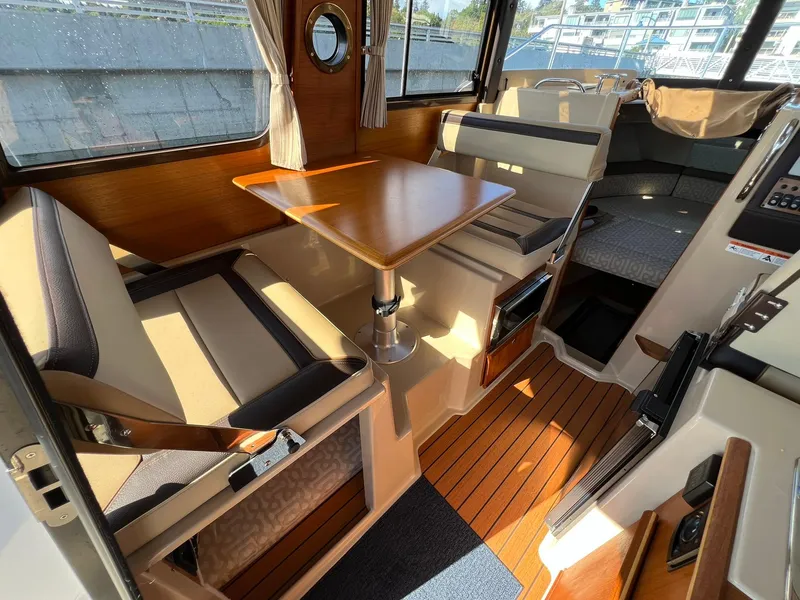 Slide: The Image of Interior of 2018 Ranger Tugs R23 boat with seating, table, and wood accents. - 13