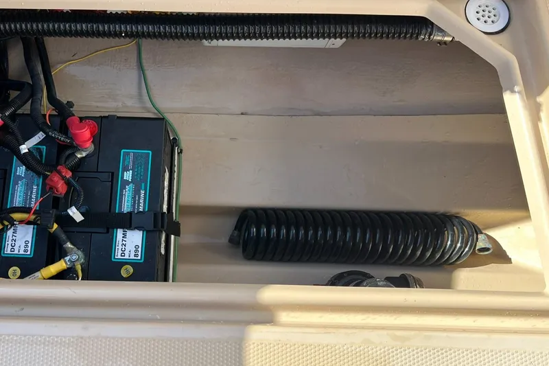 Slide: The Image of 2018 Ranger Tugs R23 battery compartment with wiring and hose. - 22