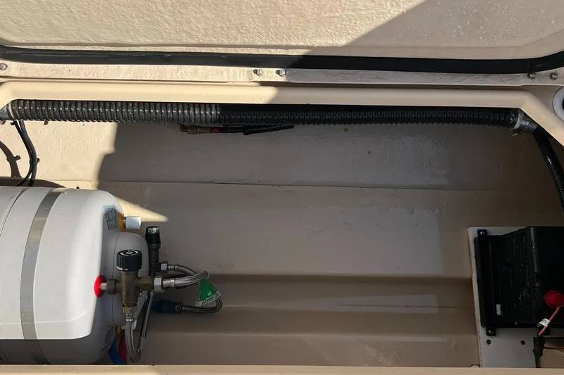 Slide: The Image of 2018 Ranger Tugs R23 engine compartment with water heater and wiring. - 23