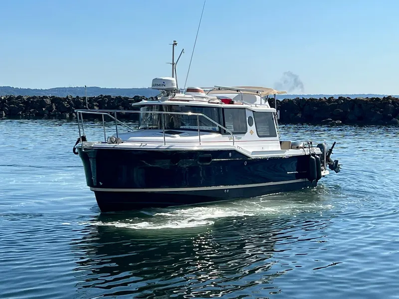 Slide: The Image of 2018 Ranger Tugs R23 boat cruising on calm water near rocky shoreline. - 4
