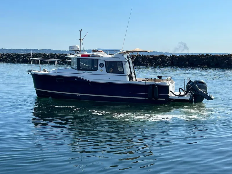 Slide: The Image of 2018 Ranger Tugs R23 boat on calm water near rocky shoreline. - 6