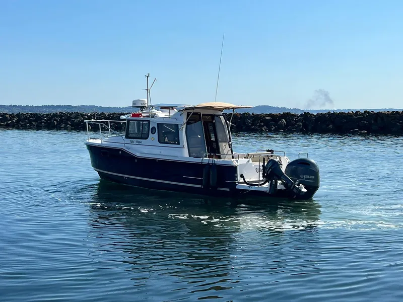 Slide: The Image of 2018 Ranger Tugs R23 boat on calm water near rocky shoreline. - 7